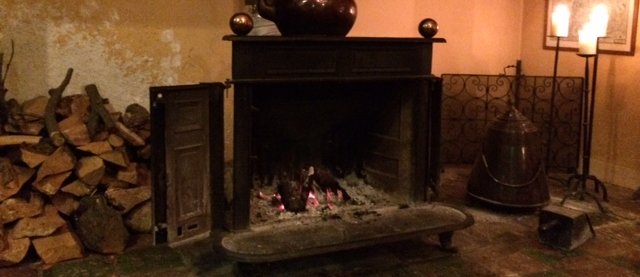 Mooie open haard met zitbanken bij De mooie serre van landhuis De Jufferen Lunsingh