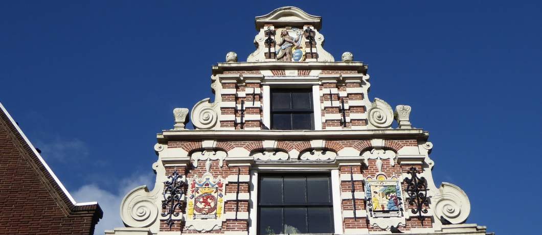 Marktmeestershuis met emblemen tijdens de stadswandeling door Enkhuizen
