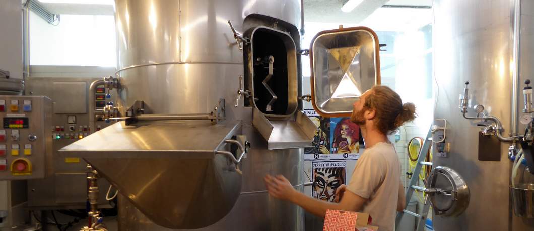 Brouwer Erik van Homeland Brewery kijkt in zijn bierketel