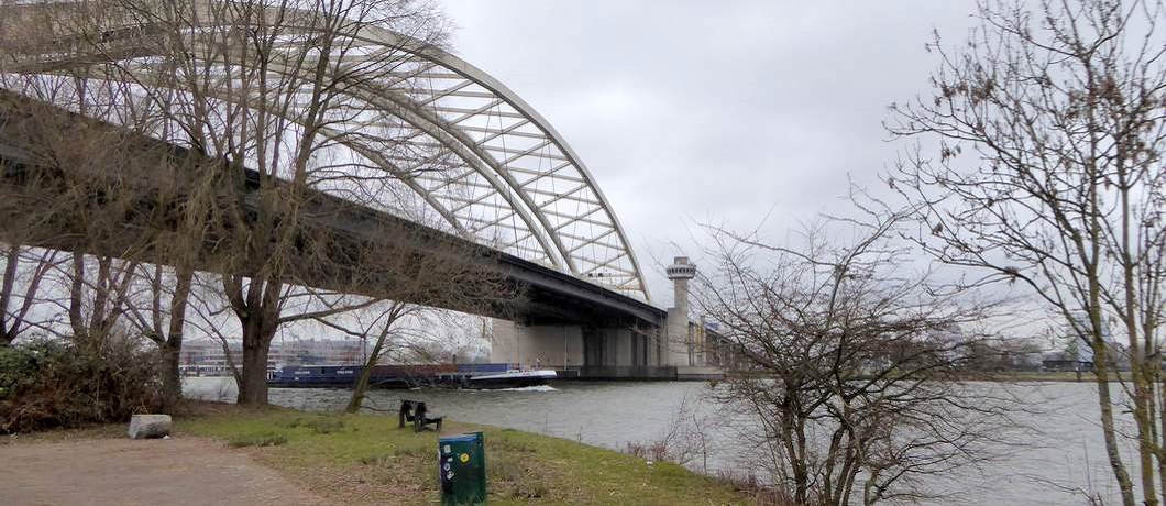 Vanaf het bankje kijk je over de Nieuwe Maas en de Van Brienenoordbrug