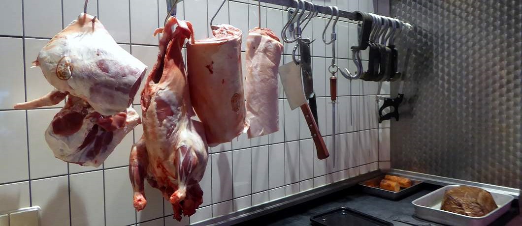 Het lam hangt in stukken aan de haken bij slagerij de Wit