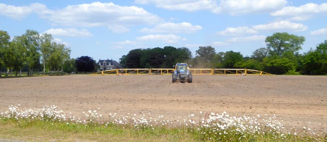 Boer aan het werk met zijn tractor tijdens het fietsen in het Reestdal