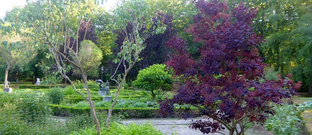 Overzicht van de tuin bij het ondergaan van de zon in beeldenpark De Havixhorst