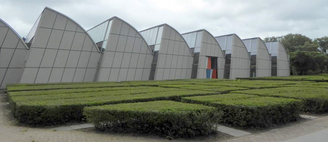 De loodsen van Weverij De Ploeg lijken over te hellen, onderdeel van de Rietveldwandelroute in Bergeijk