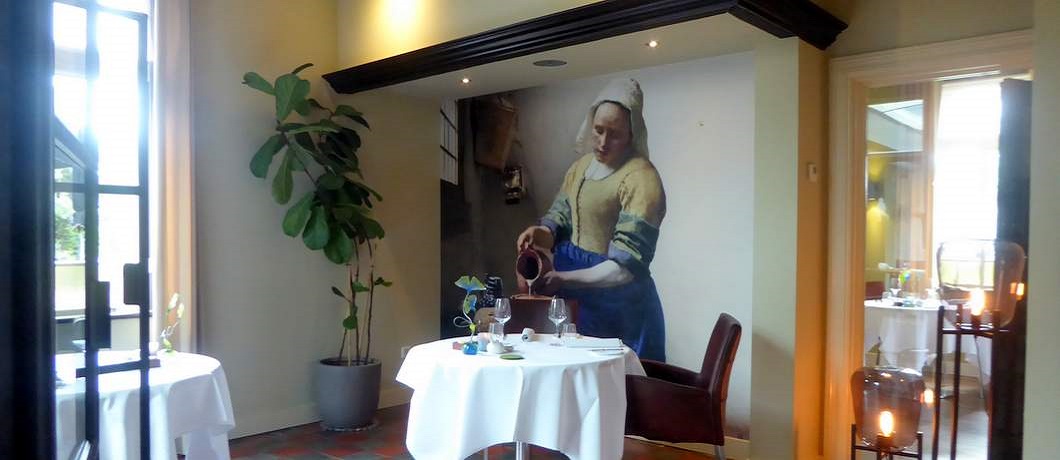 Het Melkmeisje van Vermeer op de muur bij restaurant Vandeijck