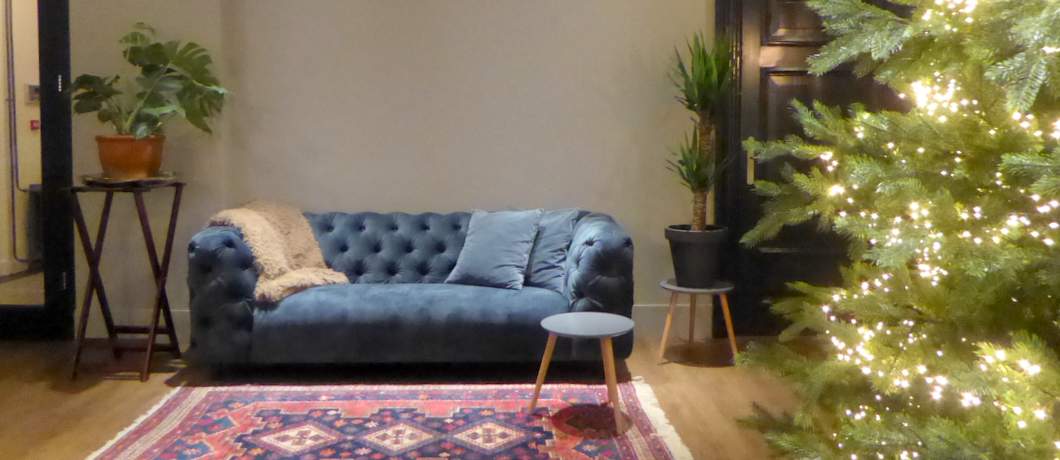 Comfortabele bank met Perzisch tapijt in hotel De Heerlyckheid