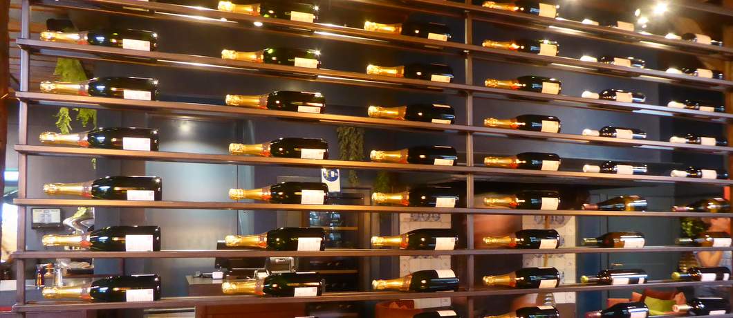 Een wand van wijnflessen middenin restaurant de Oude Apotheek