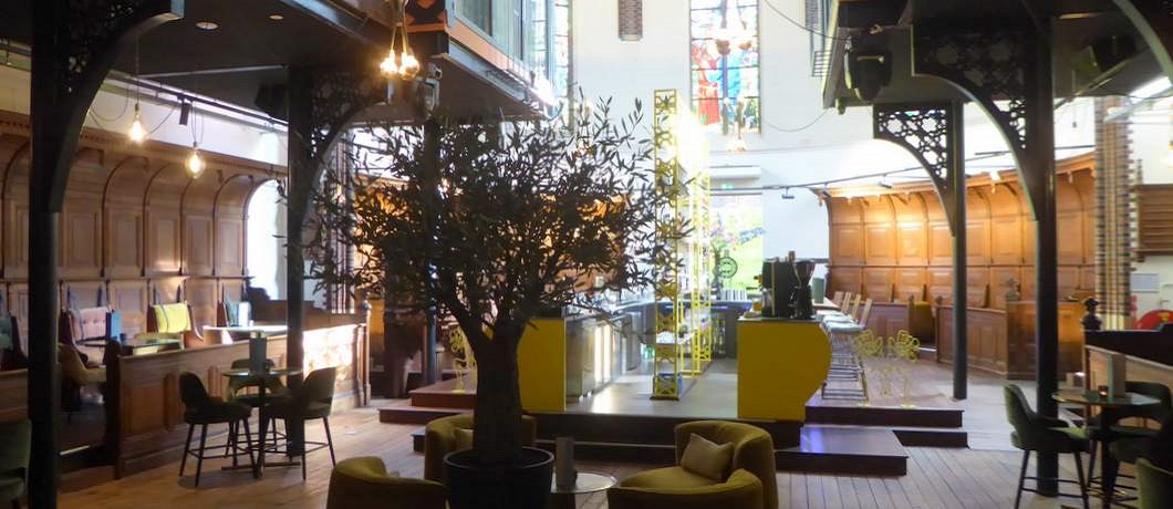 Restaurant The Church met olijfboom en glas-in-loodramen op de achtergrond