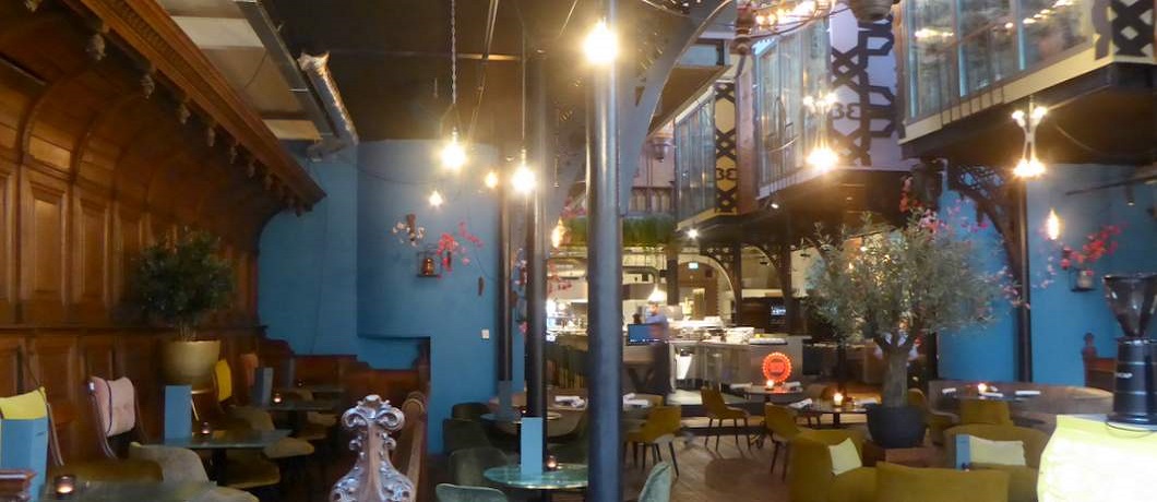 Het restaurant van The Church met overal zitjes en de bar middenin de kerkzaal