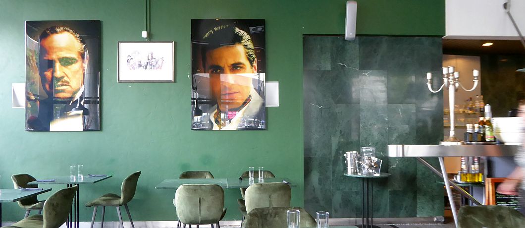 Aan de muur afbeeldingen van de Godfather in Trattoria A Proposito in Rotterdam