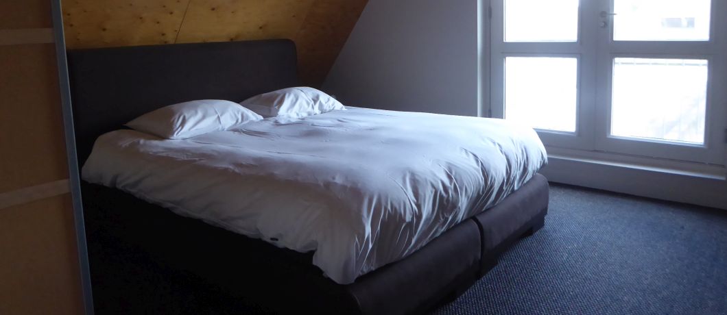 Een van de sobere en functionele slaapkamers in vakantiehuis De Takomst in IJlst