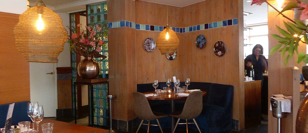 Houten tafels en linnen servetten bij brasserij Kok Vehoeven in Tilburg.