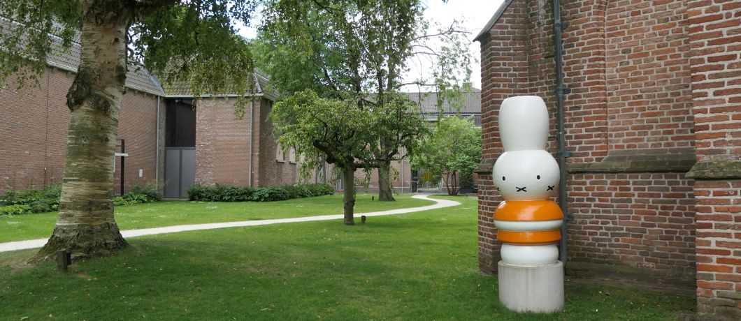 Het pad door de immense en groene museumtuin van Museumcafé Centraal met een beeld van Nijntje