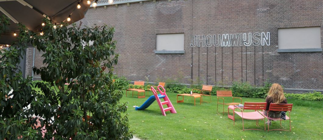 Moderne kunst en stoelen verspreid in de tuin van Museumcafé Centraal in Utrecht